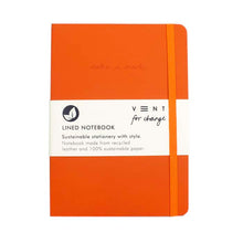 Load image into Gallery viewer, Front of Orange A5 Recycled Leather lined notebook. Removable white paper band around the middle reads: &#39;Lined Notebook Sustainable Stationery with style. Notebook made from recycled leather and 100% sustainable paper.&#39; An orange elasticated band loops around the front. &#39;Make a mark&#39; is engraved on the front cover.

