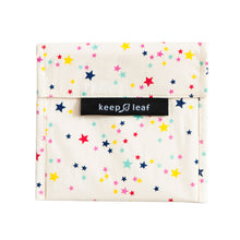 Load image into Gallery viewer, Fabric bag with foldover flap. Black fabric tag reads &quot;keep leaf&quot;. Design shows blue, pink, red and yellow stars on a white background.

