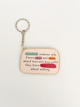 Load image into Gallery viewer, Keyring reads &#39;Scientist: someone who knows more and more about less and less until they know everything about nothing&#39;. Words &#39;scientist&#39;, &#39;more&#39; and &#39;everything&#39; are highlighted. A small chain leads to a keyring attachment.
