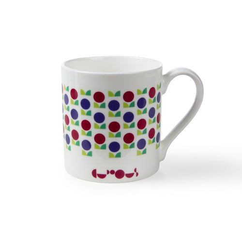 White mug shows pattern of red and purple flowers with green leaves. Underneath the design the We The Curious logo is in red. 