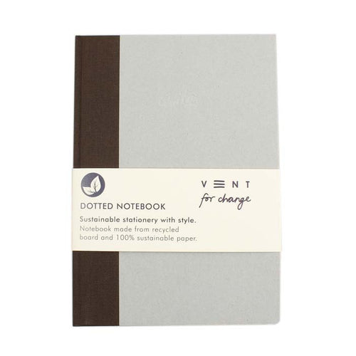 Notebook is grey with brown spine. Notebook is wrapped with paper band packaging. Packaging shows 