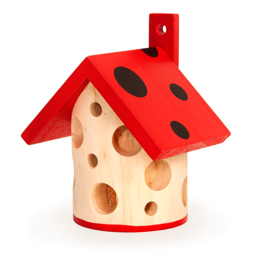 Red roofed wooden cylinder with various sized holes. Roof has black spots. A post at the back has a small hole. 