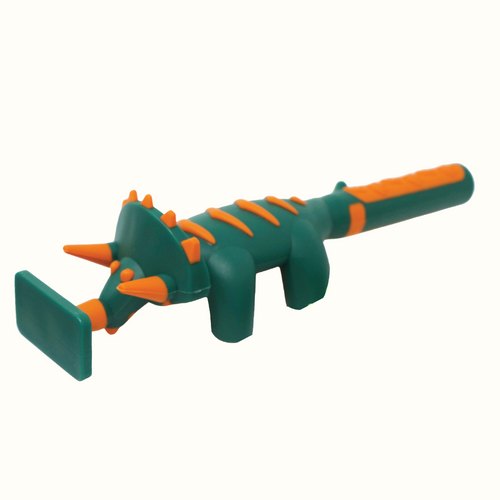 Dinosaur pusher has a flat plate on the end of the triceratops face. Pusher sits on 4 dinosaur legs. Dinosaur is dark green with orange accents. 