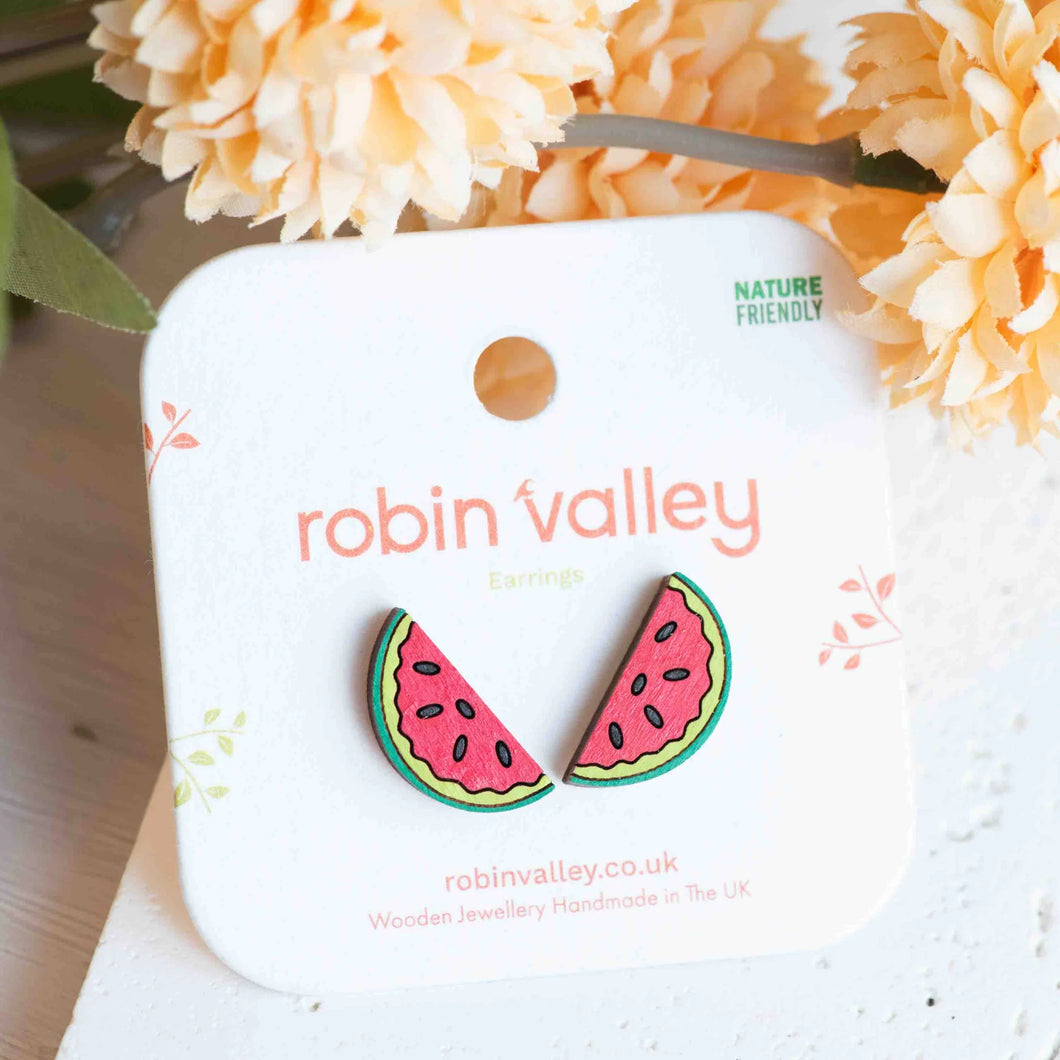 Watermelon slice earrings on a 'Robin Valley' branded card with flowers in the background