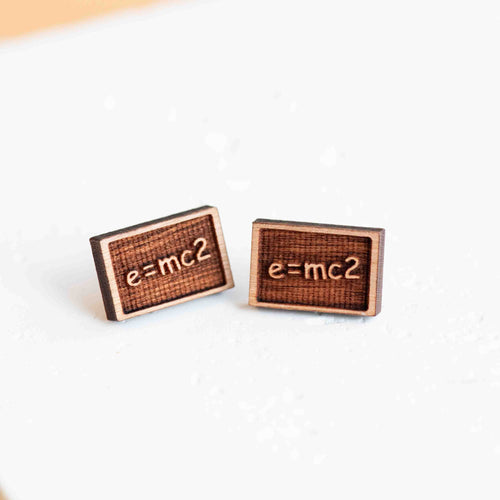 Two wooden rectangular earrings with a border show e=mc2 on a chalkboard.