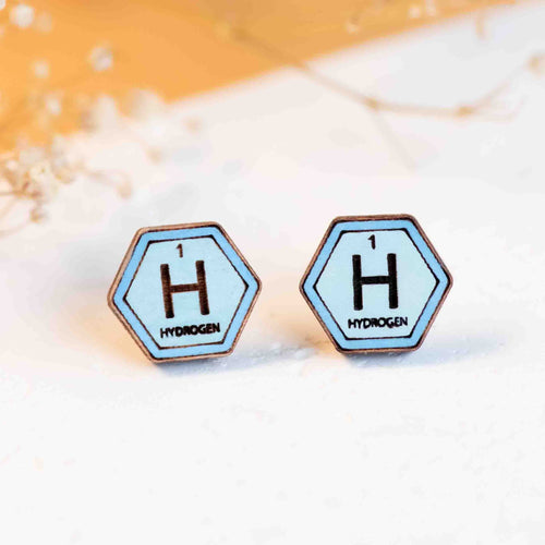 Two blue hexagonal earings with a darker blue border, and a '1', an 'H' and the word 'Hydrogen' in black. 