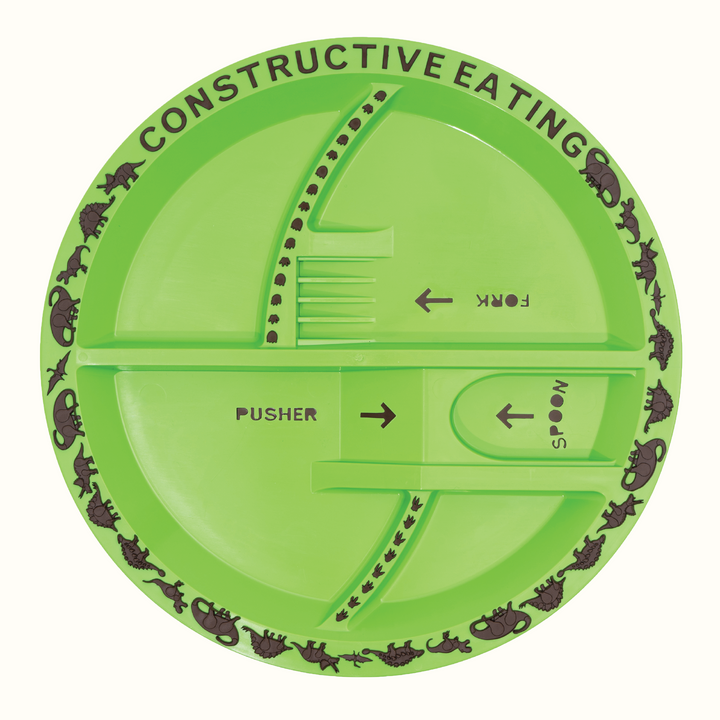 Plate is light green with brown details. Around the edge of the plate reads 'constructive eating' in capital letters and 6 dinosaur designs on repeat. Plate separated into 4 sections with labels for fork, pusher and spoon. Indents for each of these utensils are on the plate. On the ridges of the sections are dinosaur footprints. 