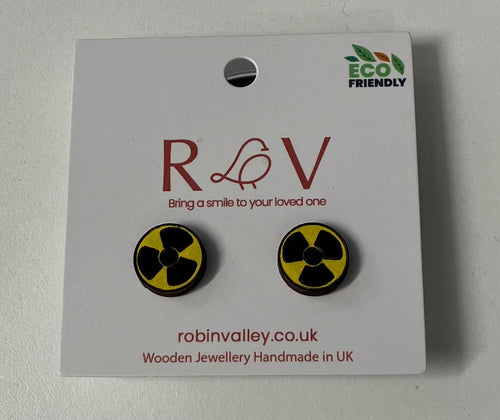 Two round earrings with the radioactive symbol (yellow background with a black shape like a fan). Earrings attached to a white card with the Robin Valley logo. Card reads 'eco friendly, bring a smile to a loved one, robinvalley.co.uk, wooden jewellery handmade in UK'. 