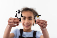 Load image into Gallery viewer, Blurred child holds two focused assembled sheep towards the camera. 
