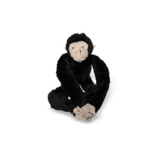 Load image into Gallery viewer, a black monkey plush sitting with its arms and legs crossed
