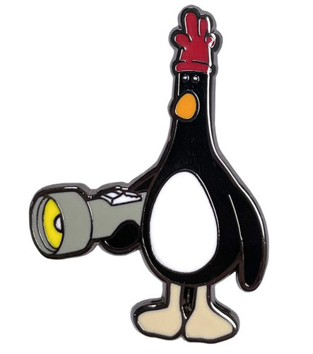 Pin badge shaped as penguin with red glove on its head, holding a torch. 