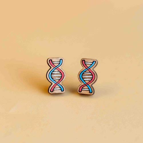 Two wooden earrings shaped and painted in red and blue spirals with white lines connecting the spirals. 
