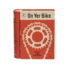 Load image into Gallery viewer, Orange tin made to look like a book. A white illustration of a bike chain is on the cover, with the words &#39;on yer bike, a cyclists guide to basic maintenance.&#39; 
