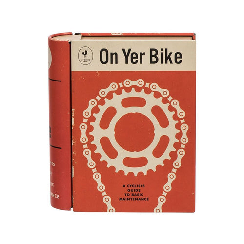 Orange tin made to look like a book. A white illustration of a bike chain is on the cover, with the words 'on yer bike, a cyclists guide to basic maintenance.' 