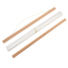 Load image into Gallery viewer, Two sections of wood on either side of a roll of paper with elastic band. One wooden bar has white string attached.
