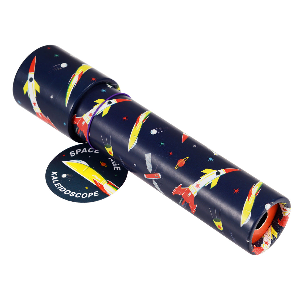 Blue tube with colourful illustrations of white, yellow and red rockets, planets and stars. A tag is attached with a purple band. On one end of the tube is a small hole. 
