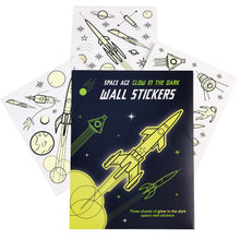 Load image into Gallery viewer, Dark blue packaging with yellow rocket illustrations reads &quot;Space Age Glow in the Dark Wall Stickers. Three sheets of glow in the dark space wall stickers&quot;. Underneath this packaging, three sheets of stickers are spread out. 
