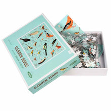 Load image into Gallery viewer, Open puzzle box with lid leaning at an angle. Puzzle pieces are inside a plastic bag and underneath that is a piece of paper with the puzzle illustration. 

