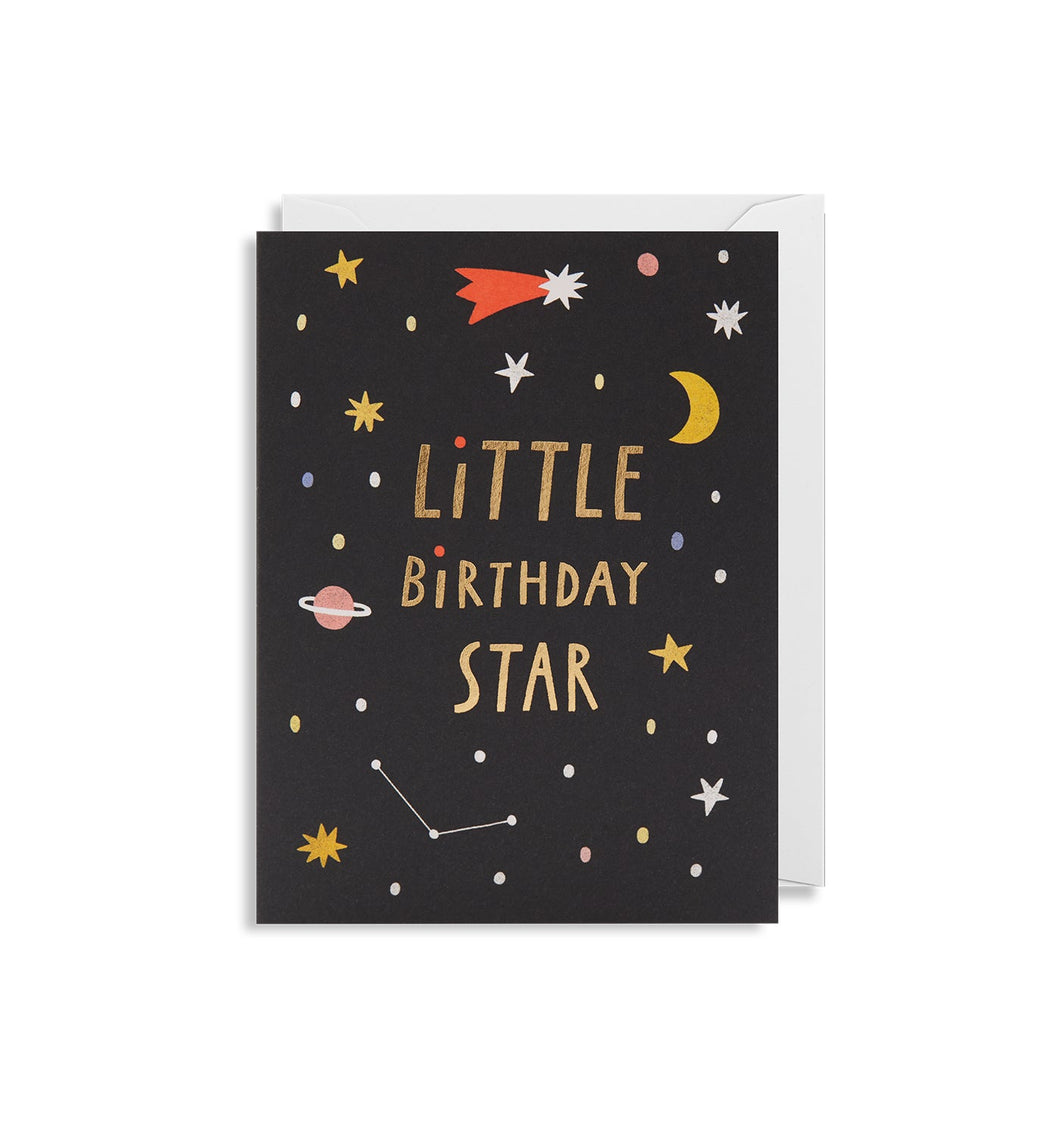 Black card with white envelope tucked inside. Card has small yellow and white illustrated stars, various coloured dots, a pink-ringed planet, a constellation, a yellow crescent moon, and a shooting star with a red trail. In gold capital letters, card reads 'little birthday star' with one word on each line.