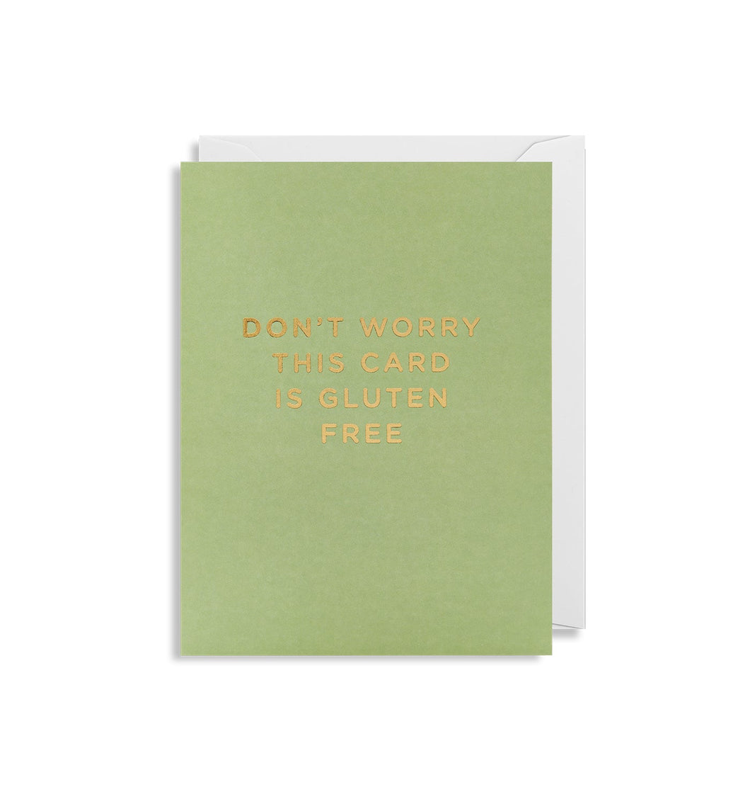 Green card with white envelope tucked in. In gold foil capital letters, the card reads 'don't worry this card is gluten free'