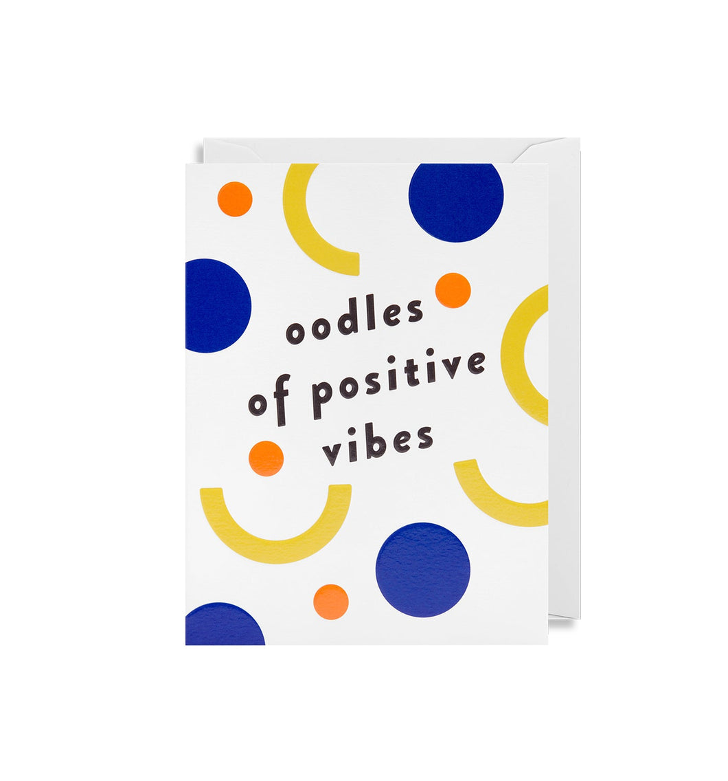 White card with blue and orange circles, yellow arches. 'Oodles of Positive vibes' is written in lowercase black letters. White envelope is tucked inside.