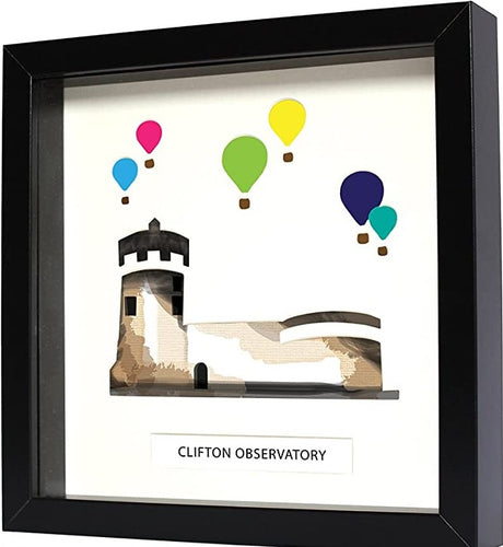 Black square frame surrounds artwork. White card paper sits atop coloured paper depicting Clifton observatory and 6 colourful hot air balloons (light blue, pink, green, yellow, dark blue and teal). Below the art is the text reading 'Clifton observatory' in black capital letters. 