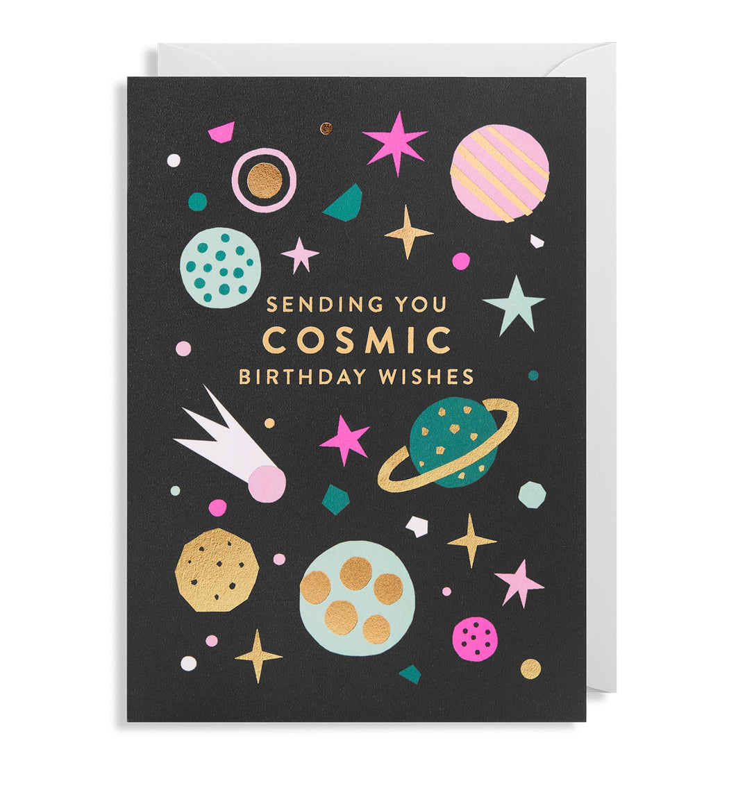 Black card with white envelope tucked in. Colour and foil illustrations include planets, stars, and meteors. In the middle, gold-foil capital letters read 'sending you cosmic birthday wishes'.