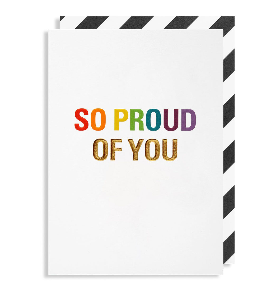 White card with 'so proud of you' written in rainbow colours and gold lettering. Black and white diagonally striped envelope tucked inside card.