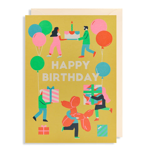 Yellow happy birthday card has colourful (pink, green, blue and orange) illustrations of 5 people with balloons and gifts. A white man is carrying a cake with a woman with red skin. A man with red skin and a white woman are each carrying a present. A white person hidden behind a massive dog shaped balloon. 'Happy Birthday' is written in bold capital white letters in the middle.