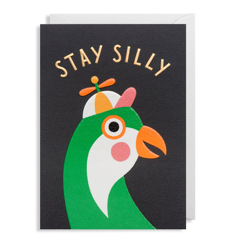 Stay silly card is black with a green bird wearing a hat with a propeller. Text across the top is capital gold letters reading 'stay silly'.