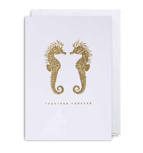 White card has two gold foil seahorses facing each other and the phrase 'together forever' in capital gold foil letters. Envelope inside card is white.