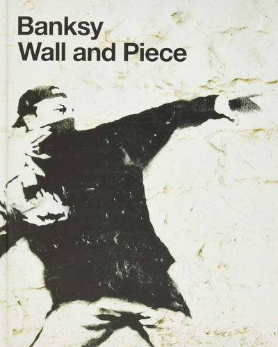 Off white book cover reads 'Banksy, Wall and Piece' in bold black letters in the top left corner. The image on the cover is a photo of Banksy's work of a man with a hat and his mouth covered, wearing a black coat, pointing ahead and reaching backwards. 