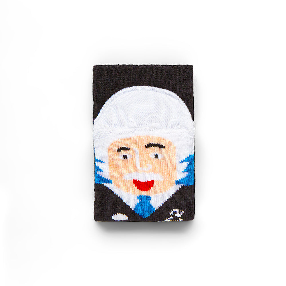 Folded black sock shows a face on the toe part with white hair, black jumper, and blue tie. Face is sticking their tongue out.
