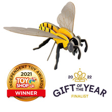 Load image into Gallery viewer, Photo of the fully assembled colourful cardboard bee with the two awards graphics below. Bee has a yellow body with black stripes, eyes and antenae, and grey wings. 
