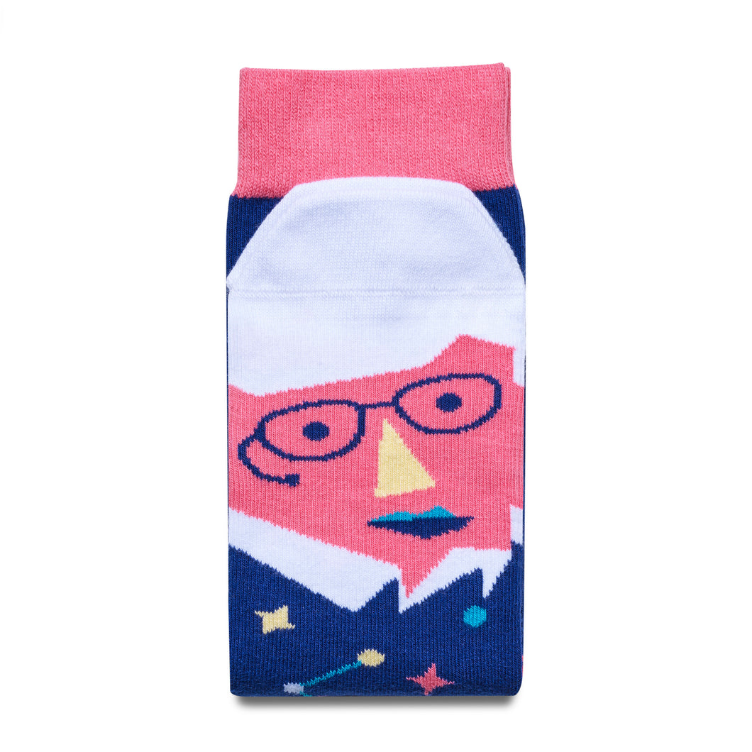 Folded dark blue socks with pink trim. The pink face on the feet has white hair and glasses. 