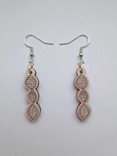 Earrings have three spirals of the DNA helix. Outer structural line is pink and inner lines are orange, white and pastel green. This drawing is put onto a wooden earring with sterling silver links and hooks. 