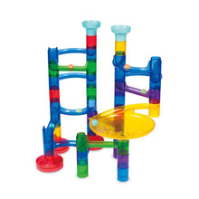 Load image into Gallery viewer, Photo of built marble run shows plastic segments in blue, green, red, purple and yellow. There are two openings for marbles at the top, several sloping arms, and one large plate style piece for the marble to go around the edge. 
