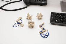 Load image into Gallery viewer, 6 wooden puzzles on a white desk next to a keyboard.
