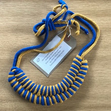 Load image into Gallery viewer, Blue and yellow necklace is tied together with a large knot. 
