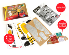 Load image into Gallery viewer, Photo of the contents of the honey bee kit show 5 press out sheets, instructions and a honey bee fact stand. Outer box is in the top left. 
