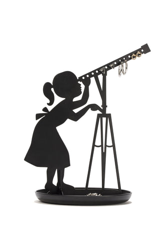 Jewellery stand with shadow of a girl in a dress with a ponytail looking through a telescope. This shadow art sits in a round tray. The telescope features 14 holes for earrings. 