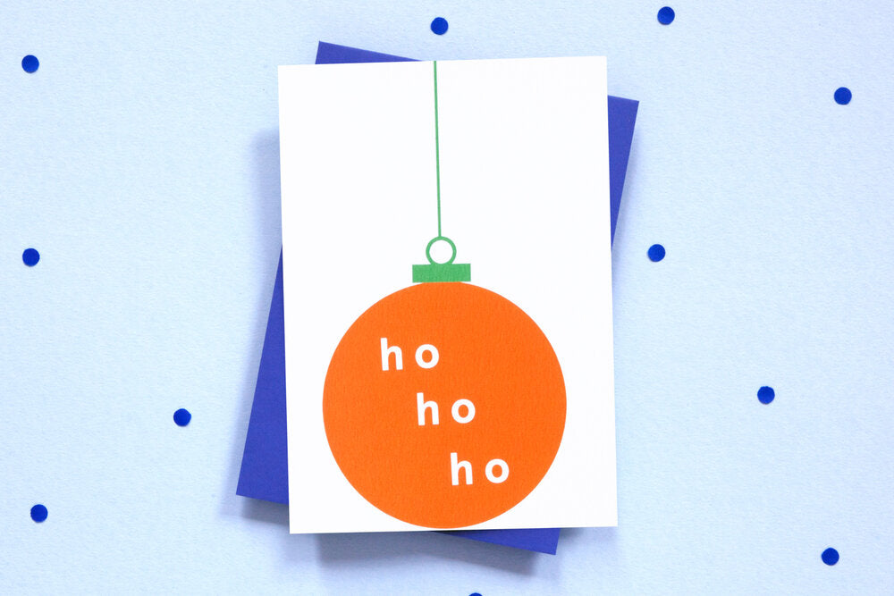White card with orange bauble and green string reads 