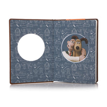 Load image into Gallery viewer, Inside front page are blueprint style illustrations of Wallace and Gromit inventions, and the illustration of Wallace and Gromit that peaks through the cover. 
