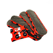 Load image into Gallery viewer, 4 open period pads with grey liner, and red wings with black dots. 1 folded pad has red fabric with black dots and 2 white snap closures. 
