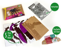 Load image into Gallery viewer, Photo of the contents of the stag beetle kit show 5 press out sheets, instructions and a stag beetle fact stand. Outer box is in the top left.
