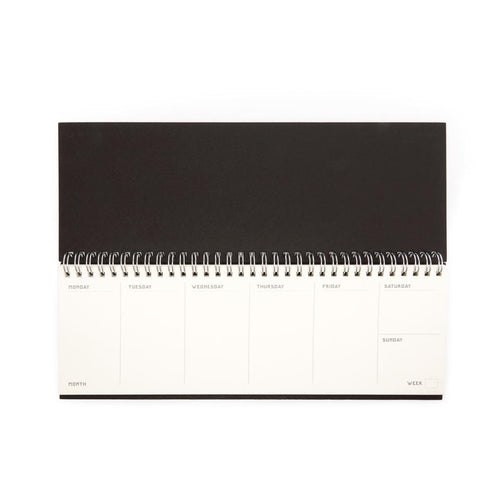 Flip notebook with the pages showing the days of the week. Calender is the size of a keyboard.