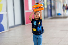 Load image into Gallery viewer, Child is holding a seacopter over her head. She is wearing a dark blue shirt with satellite shapes and blue jeans. 
