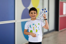 Load image into Gallery viewer, Child smiles at the camera with a robot on his shoulder. He is wearing a white shirt with cactus shapes and blue jeans.

