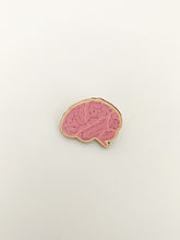 Load image into Gallery viewer, Brain wooden pin badge with pink colour and lines. Pin badge is shaped like the brain. 
