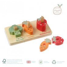 Load image into Gallery viewer, A wooden block with three differently shaped poles (square, round, triangular), has space for 1 broccoli, 2 orange carrots and 3 red strawberries. On the block sits 1 broccoli, 1 carrot and 2 strawberries. The other carrot and strawberry lie beside the board.
